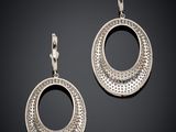 a pair of silver earrings on a black background