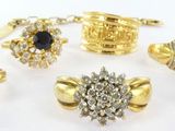 many different types of rings and bracelets on a white surface