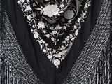 a close up of a black and white scarf with fringes