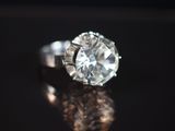 Gros plan sur une bague en diamant posée sur une surface brillante