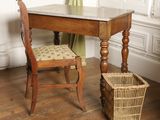 a small table with a chair and a basket on the floor