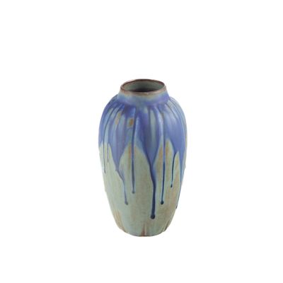 un vase bleu et blanc posé sur une surface blanche