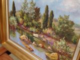 a picture of a painting hanging on a wall next to a wooden chair