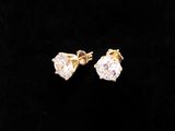 a pair of diamond earrings on a black background