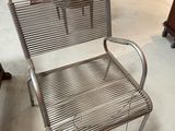 a metal chair that is sitting in the middle of a room