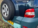 a car that is parked in the grass near a field