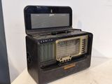 une radio à l'ancienne posée sur une table blanche