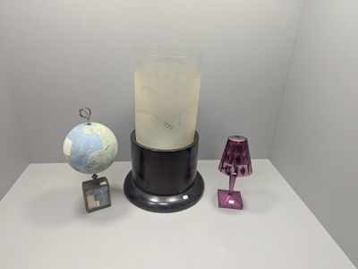 a blender sitting on a table next to a globe and a lamp