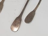 three spoons and a fork on a white table