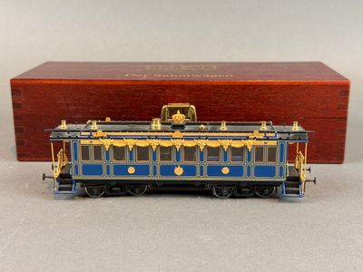 une image représentant un wagon bleu et doré posé sur une table
