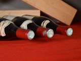 several bottles of wine are lined up on a red table