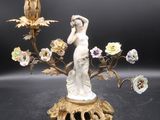 une statue représentant une femme tenant un vase orné de fleurs