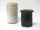 deux vases posés l'un à côté de l'autre sur une surface blanche