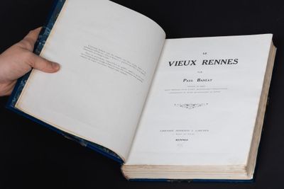 someone is holding a book open on a black surface