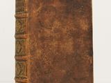 an old book sitting on top of a white surface