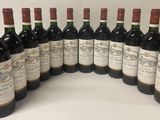 six bottles of wine are lined up in a row on a table