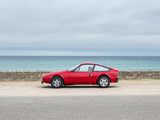 a red car parked on the side of the road near the ocean