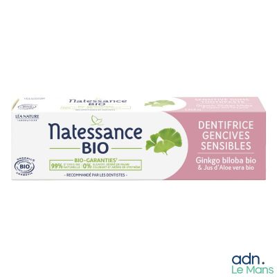 un dentifrice avec des feuilles de menthe sur fond blanc, accompagné d'une boîte de dentifrice