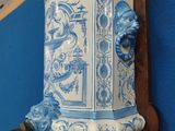 a blue and white vase on the wall next to a blue wall