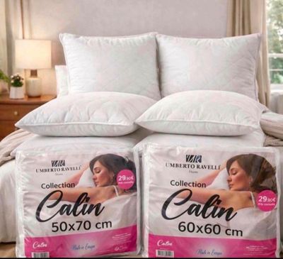 two pillows on a bed in a bedroom next to a pillow