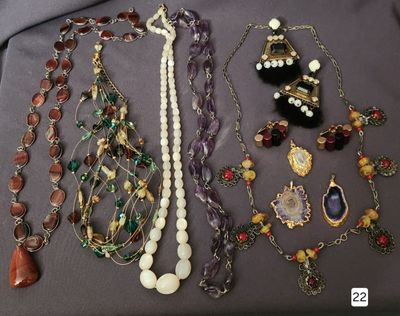 many different necklaces and bracelets that are on a table