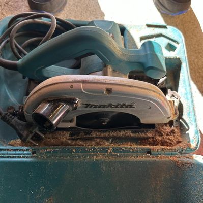a picture of a tool box with a corded saw and other tools in it