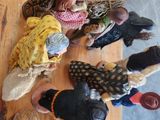 several small children are sitting on a wooden floor in a circle
