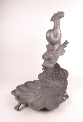 statue d'une femme avec un oiseau sur la tête, assise sur une fleur