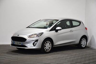 a white ford fiesta parked in a room with a checkered floor