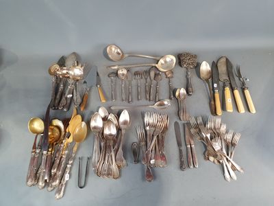 beaucoup d'argenterie sur une table avec des cuillères et des couteaux