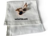 un gros plan sur une paire de boutons de manchette posés sur un tissu blanc
