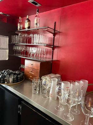 bottles and glasses are lined up on a counter in a kitchen
