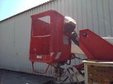 a red machine that is sitting in front of a building