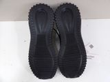 black slippers on a white surface with a box in the background