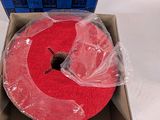 a red cake in a box that is wrapped in plastic