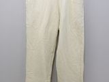 a white pants hanging on a hanger against a wall