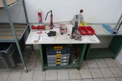 un établi sur lequel sont posés des outils, dans une pièce