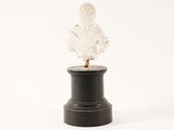 a white statue of a woman on a black pedestal
