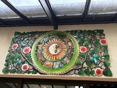 une horloge sur la façade d'un immeuble, ornée de fleurs
