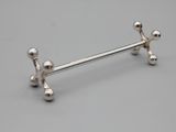 silver plated barbell with four balls and a cross on the end