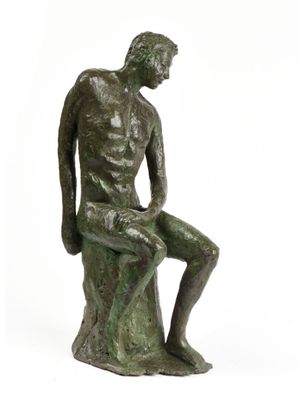 statue représentant un homme assis sur un rocher, les jambes croisées