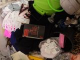 a pile of clothes and other items on a bed
