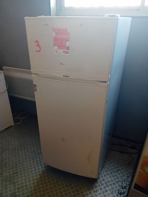 un réfrigérateur blanc dans le coin d'une pièce
