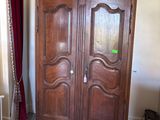 a large wooden armoire in the corner of a room