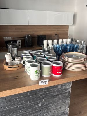 de nombreuses tasses et assiettes sur le plan de travail de la cuisine