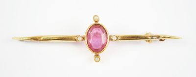 a close up of a pink stone on a gold plated pin