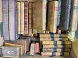 une boîte pleine de vieux livres posée sur le sol