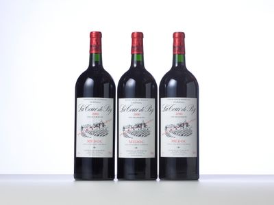 trois bouteilles de vin rouge posées sur une table