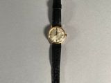 a close up of a watch on a table with a white background