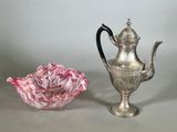 une théière en argent à côté d'un vase à roses rose